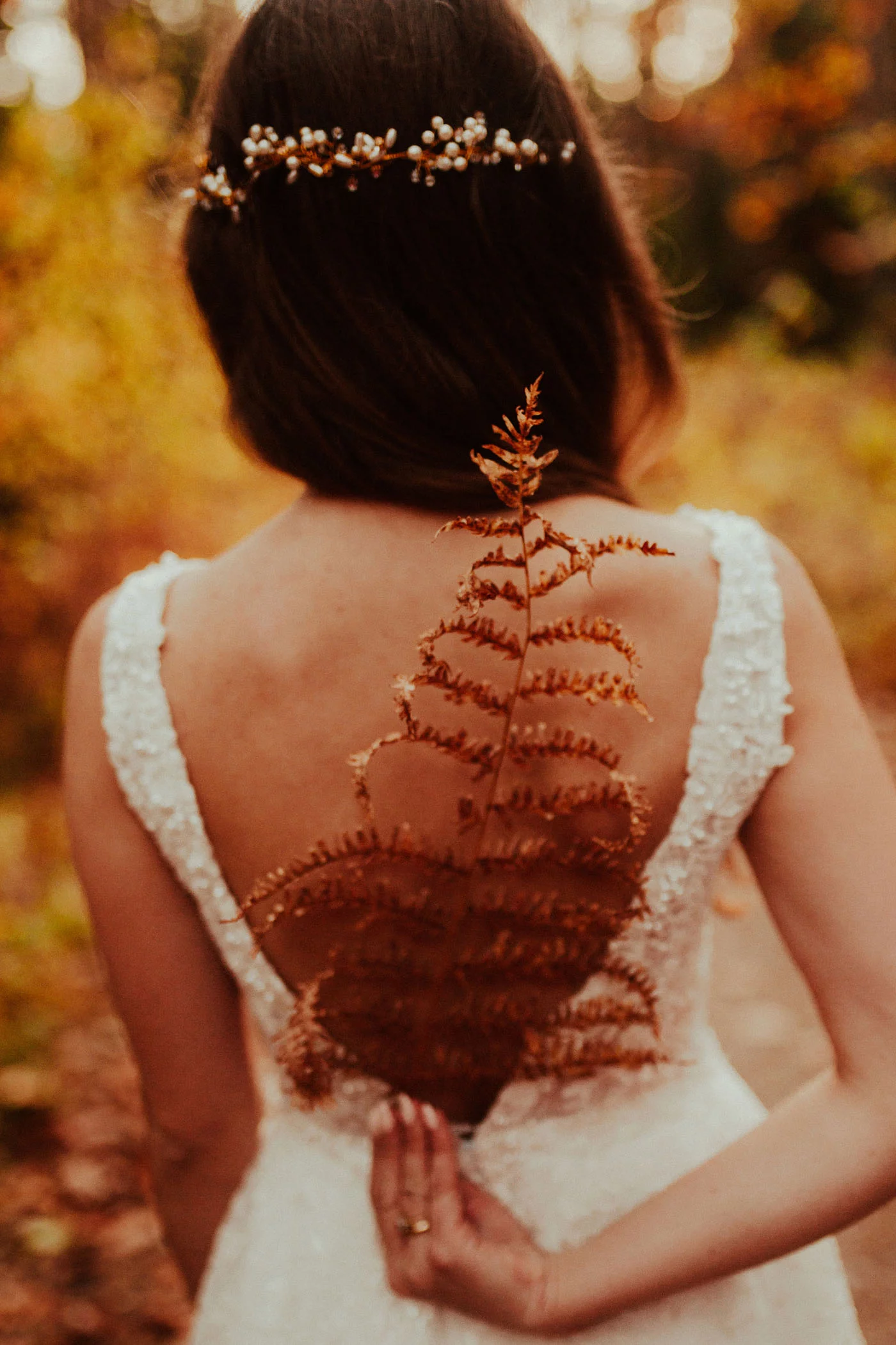 Panna Młoda trzymająca jesienną roślinę w kadrze wykonanym przez Emilię Chrobok - fotografa ślubnego z Tarnowa
